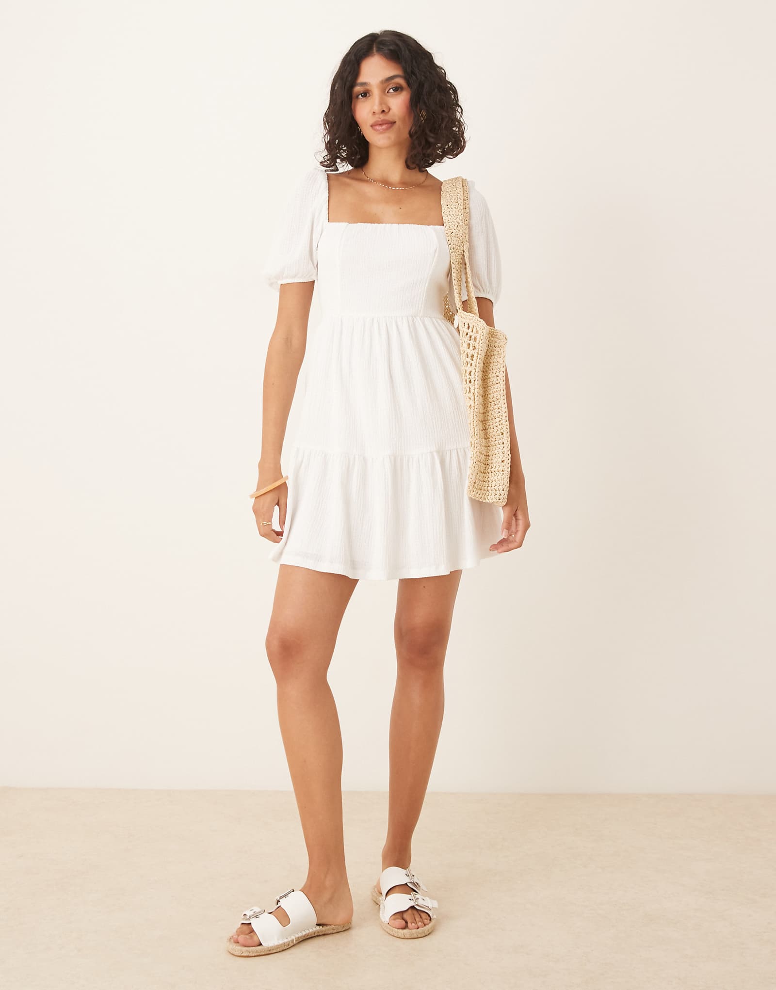 Летнее мини-платье из трикотажа Gina с коротким рукавом и завязкой на спине белоснежного цвета 14290₽