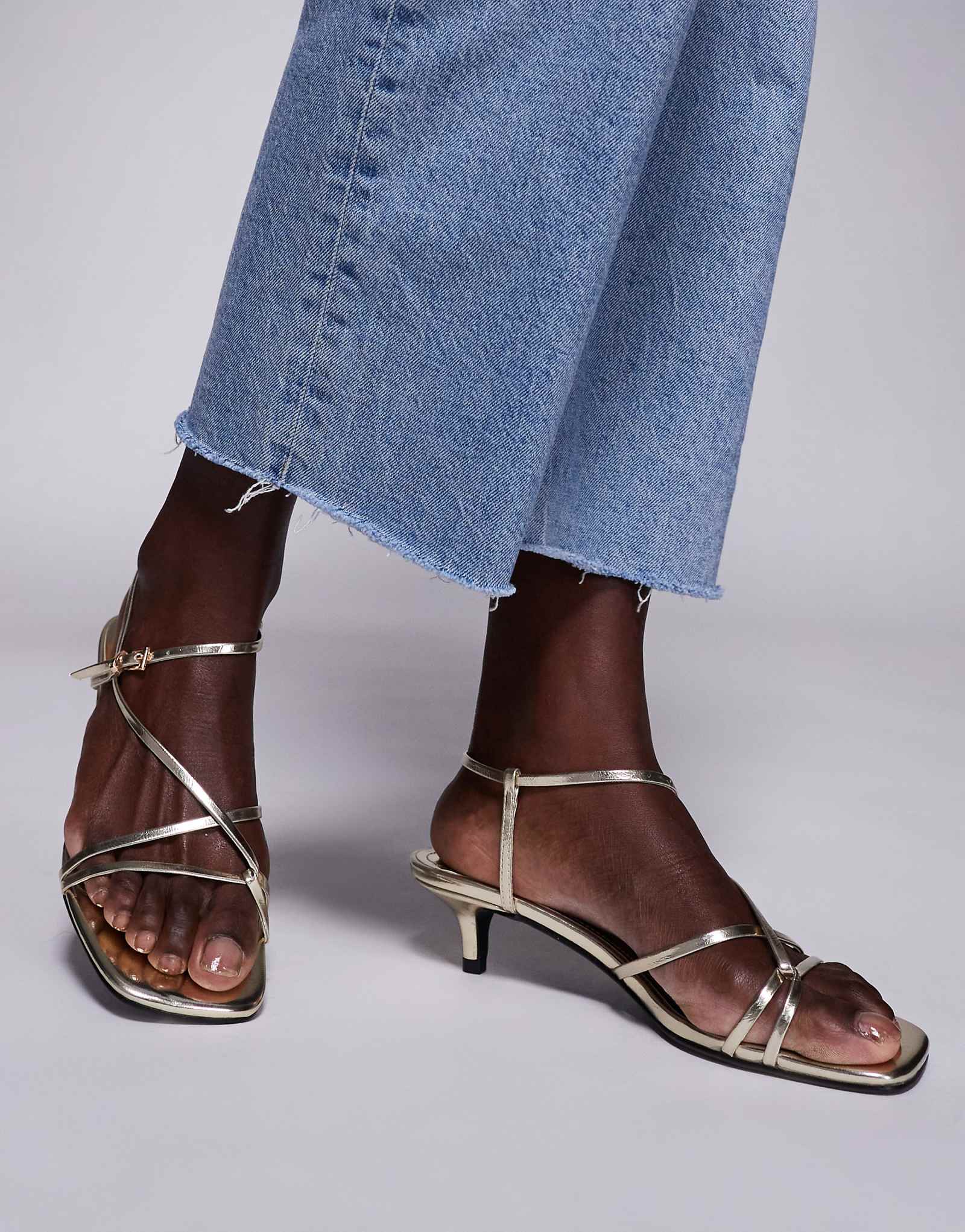 Босоножки с едва заметными ремешками из золотистого металлика, вызывающие всеобщее восхищение.