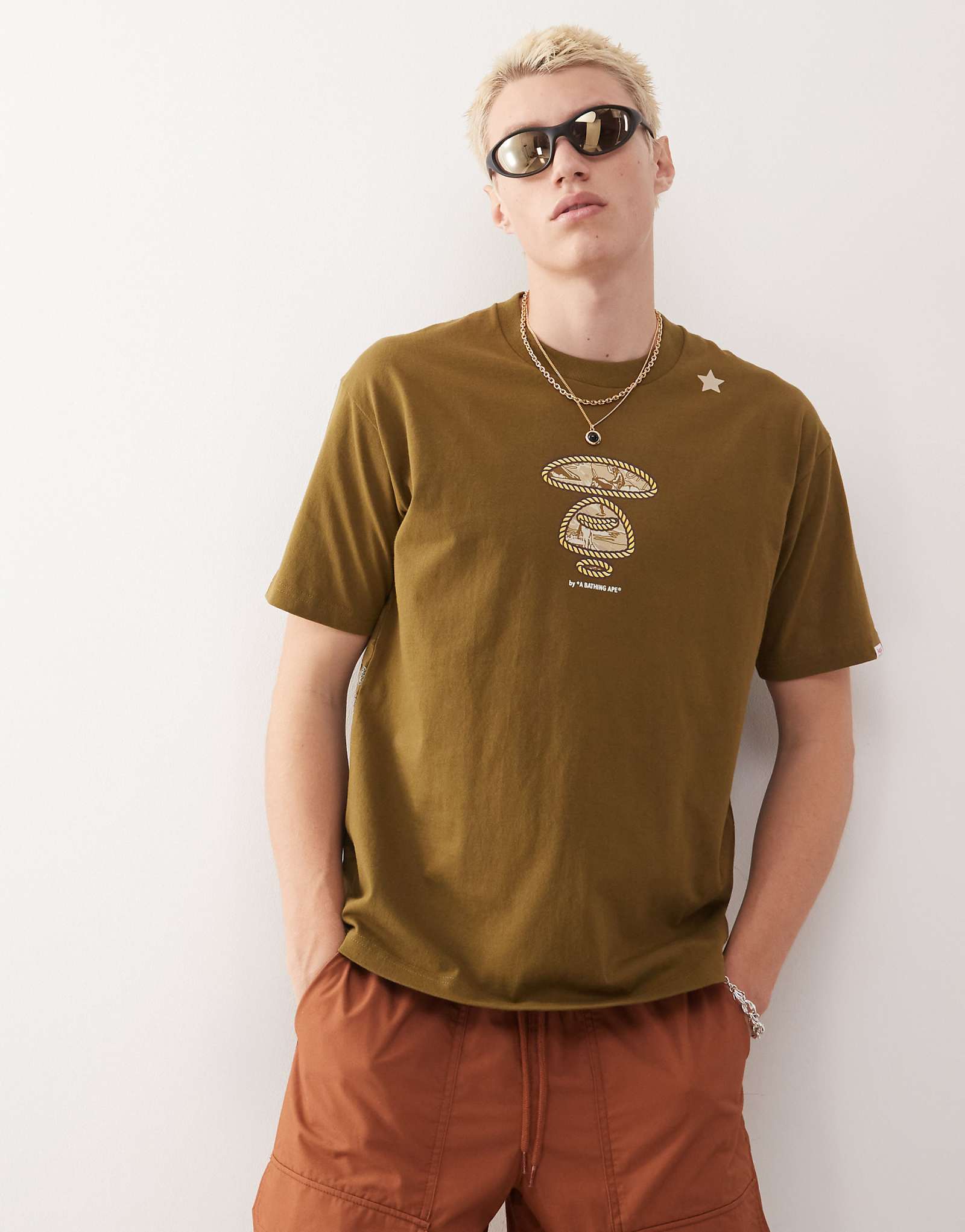 Облегающая футболка AAPE BY A BATHING APE зеленого цвета хаки с многослойным западным принтом 15290₽