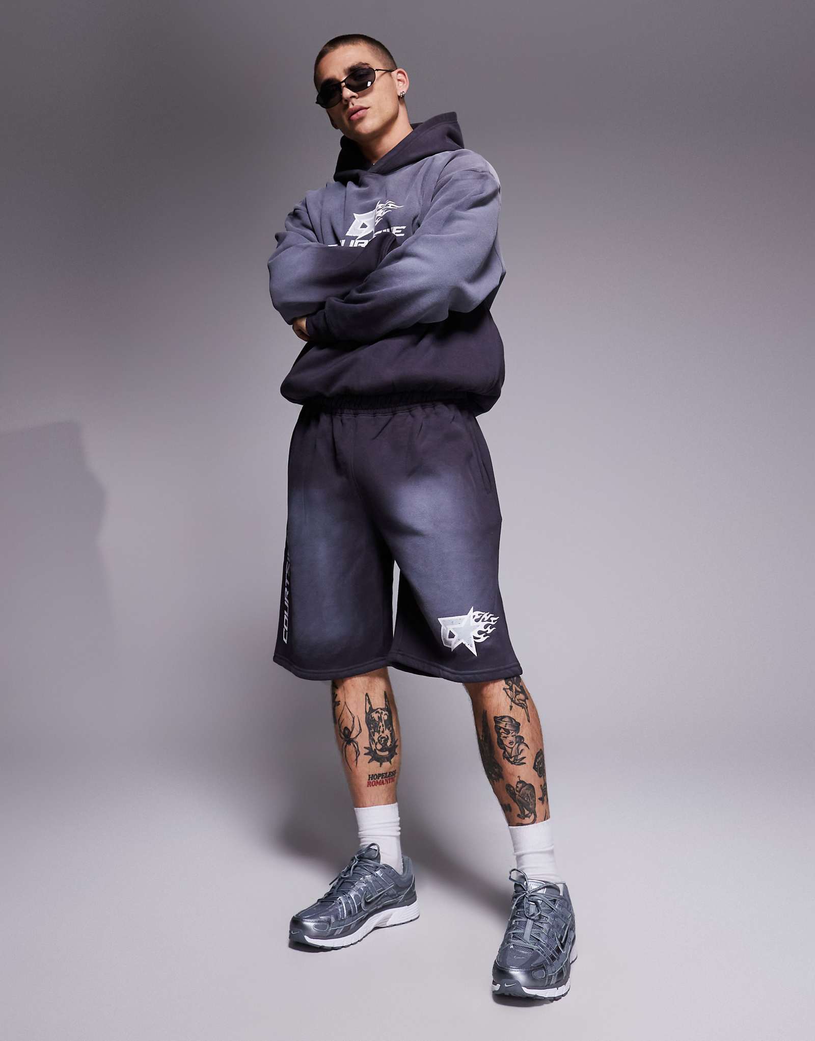 Шорты свободного кроя с логотипом по бокам серого цвета, которые являются частью комплекта