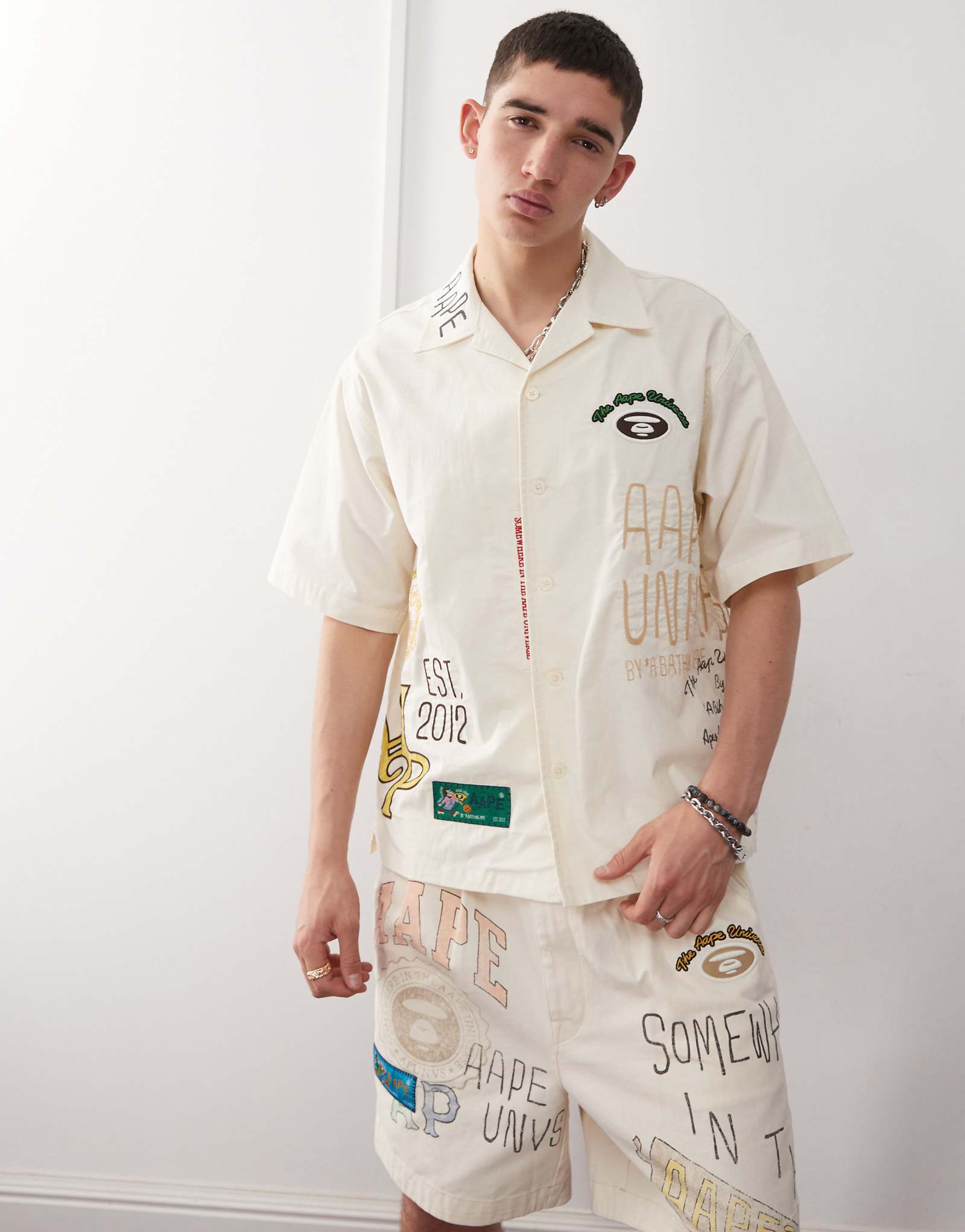 Бежевая рубашка с коротким рукавом Aape By A Bathing Ape с несколькими логотипами колледжа 39790₽