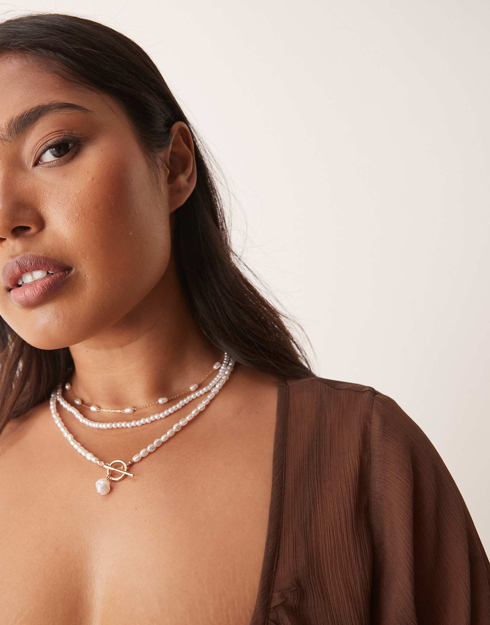 Многорядное колье ASOS DESIGN Curve с искусственным жемчугом и Т-образной планкой золотого оттенка 3490₽