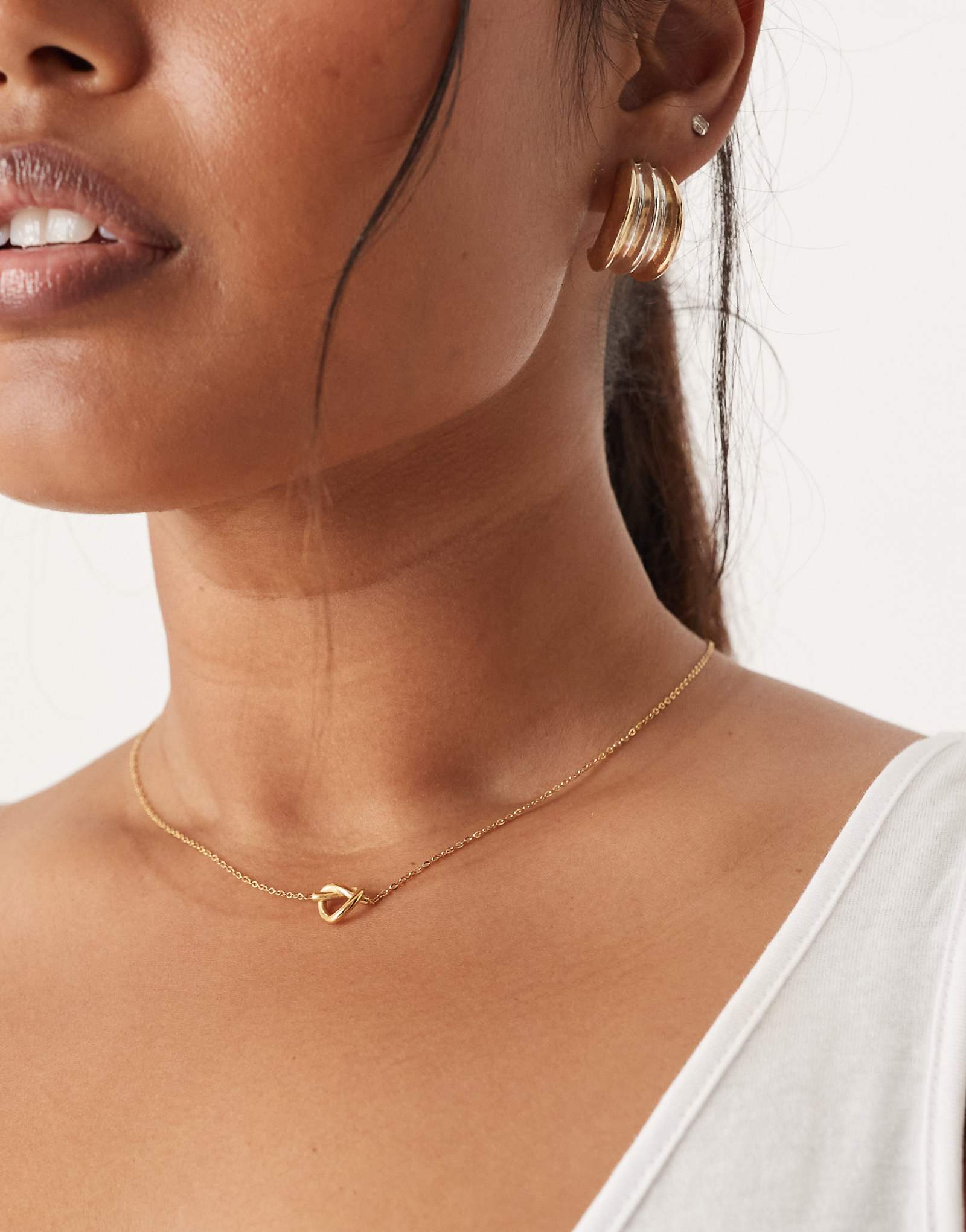 Водонепроницаемое колье ASOS DESIGN Curve из нержавеющей стали с подвеской в виде узла золотого оттенка 3490₽