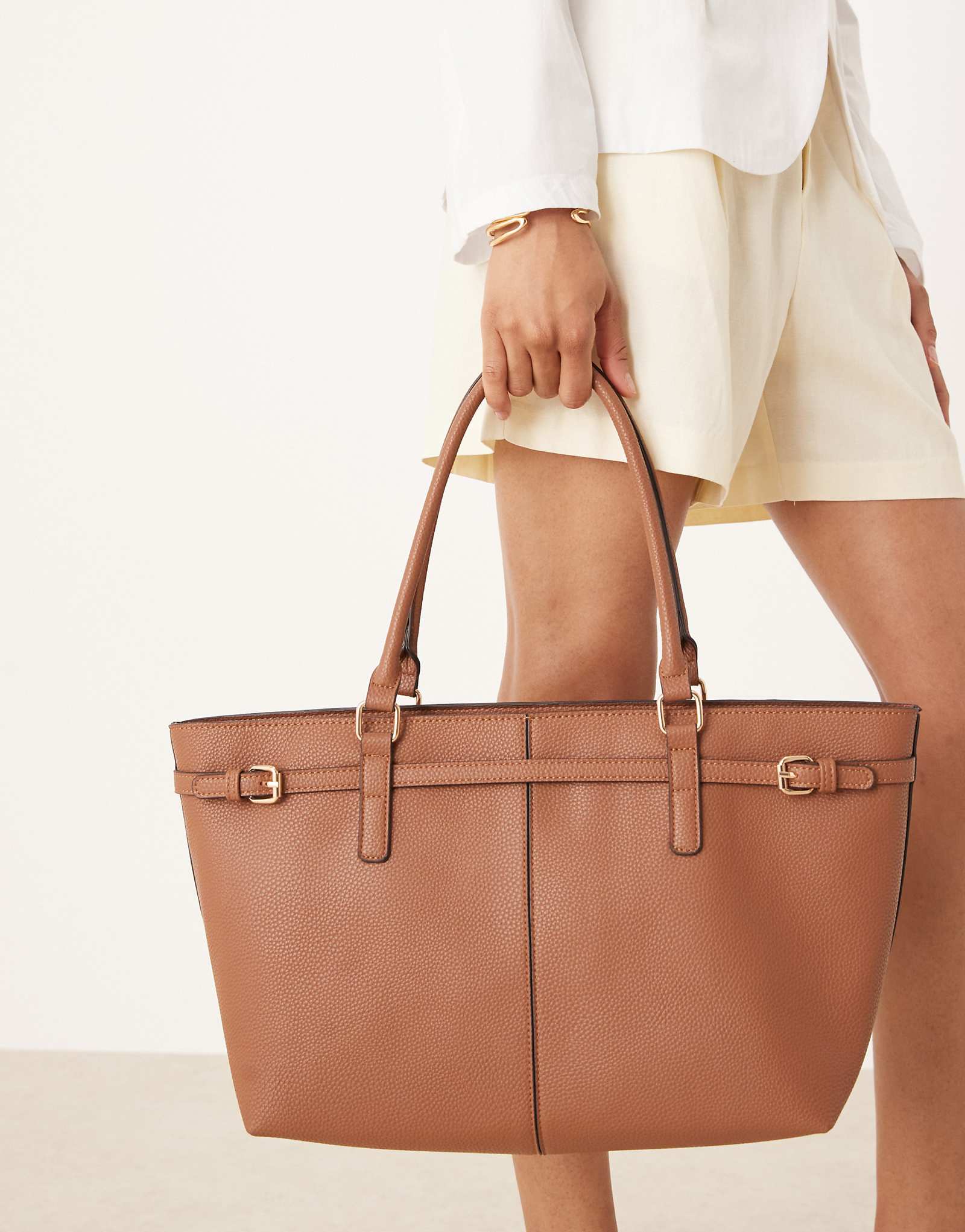 Сумка-тоут через плечо east to west с пряжкой коричневого цвета дополненная аксессуарами 13490₽