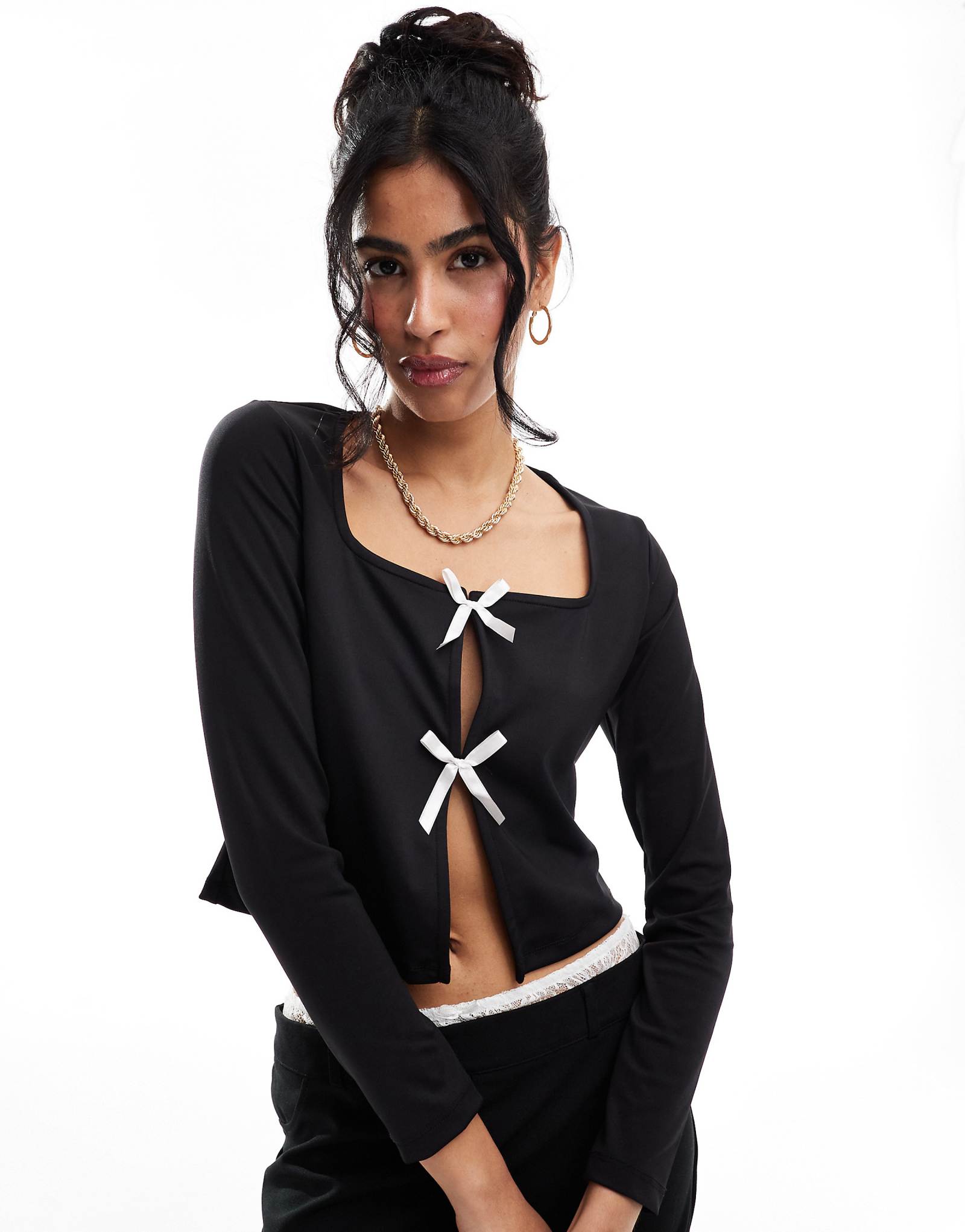 Детали сочетаются с облегающим розовым кардиганом-бабочкой спереди черного цвета 6390₽