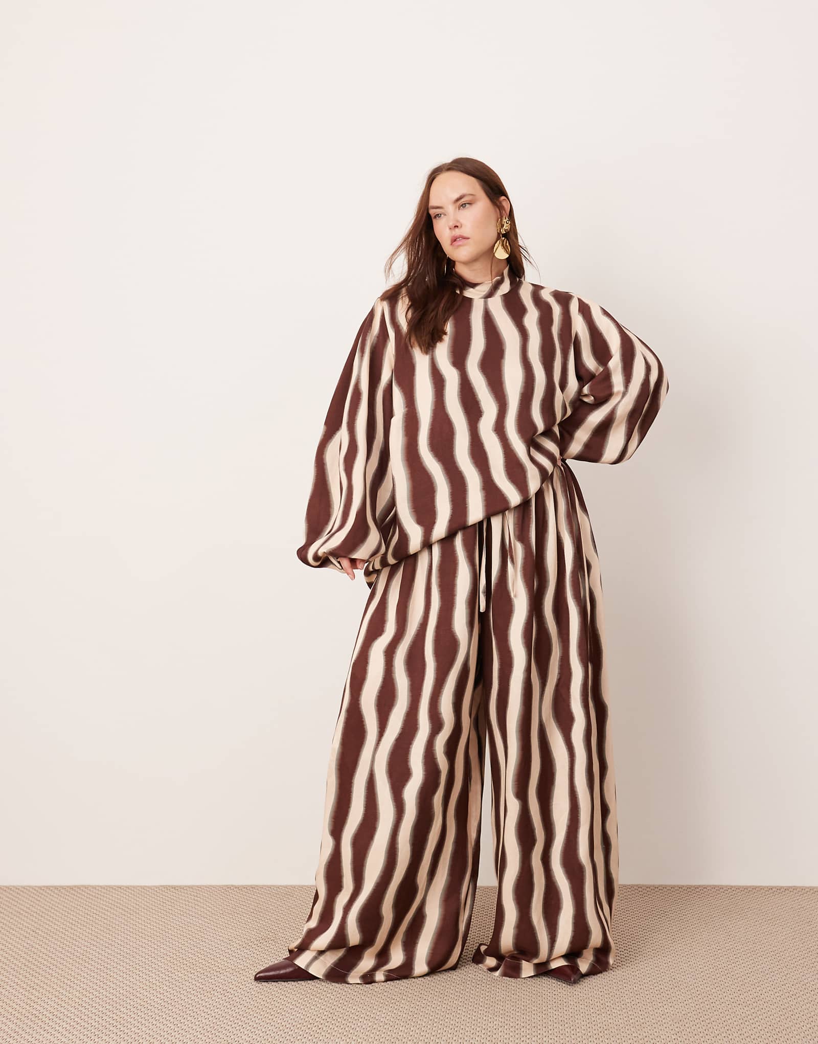 Модель ASOS EDITION Curve с очень широкими штанинами и завязками на талии с волнистым принтом шоколадного цвета - часть комплекта 17690₽