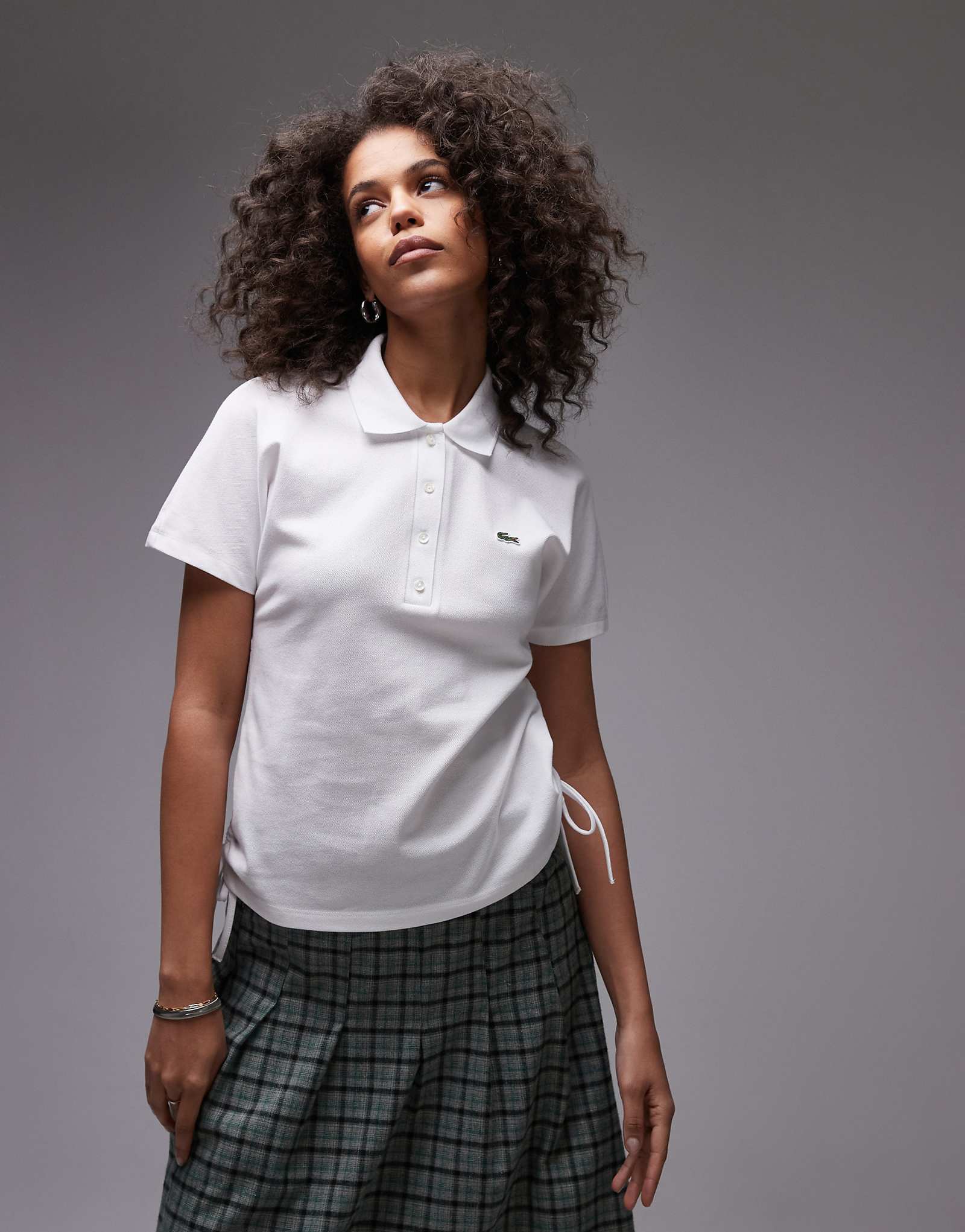 Рубашка-поло Lacoste белого цвета с рюшами на боковом шве 21090₽