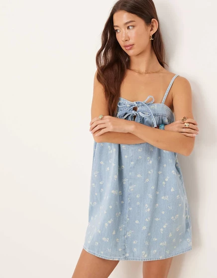 Дизайнерское мини-платье на бретелях из мягкого денима ASOS DESIGN с завязкой спереди и цветочным принтом mid blue
