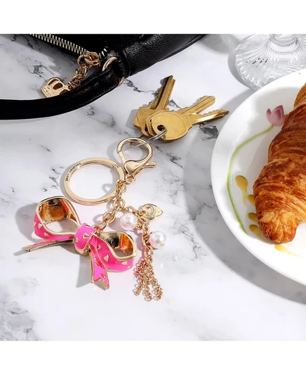 Брелок-шарм с бантом от Juicy Couture - Стильный аксессуар с золотыми и розовыми украшениями pink, gold, white
